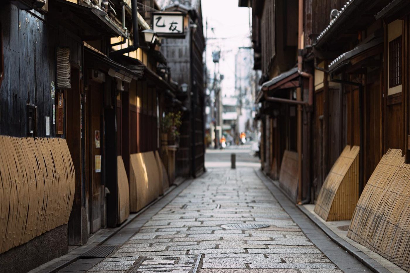Wooden machiya townhouses along a stone-paved lane in Gion, Kyoto